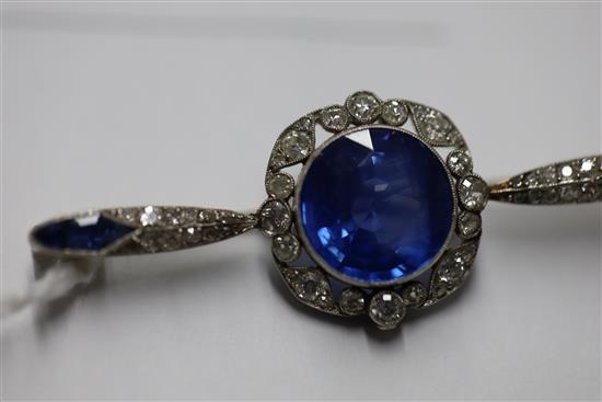 A sapphire and diamond bar brooch, the central round-cut sapphire with diamond border, flanked by marquise-set diamonds and sapphires